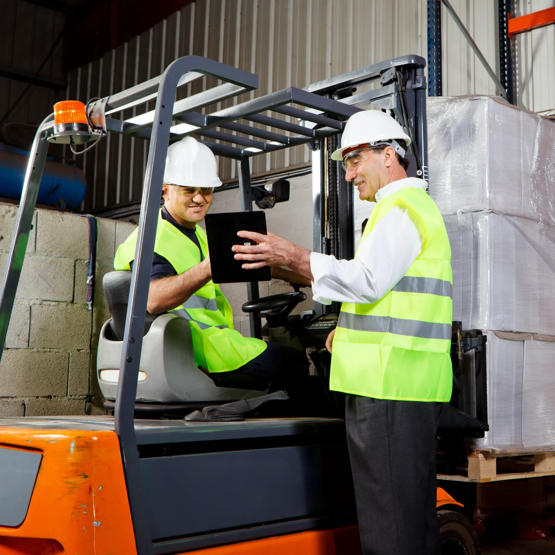 Forklift operators coordinating inventory inside a warehouse